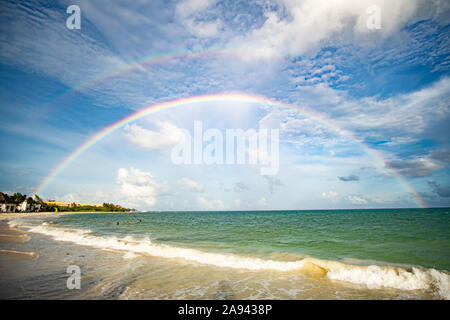 Double arc-en-ciel brillant au-dessus de la magnifique mer des caraïbes avec divisé ciel à Playa del Carmen au Mexique Banque D'Images