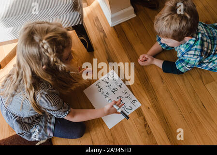 Un garçon et une fille pratique des problèmes de mathématiques. Banque D'Images