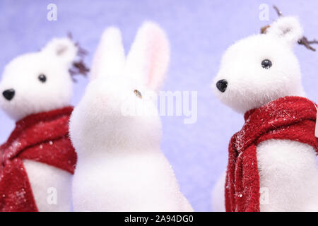 Vacances d'hiver noël home party decoration jouets mignon fluffy les animaux à fourrure lapin et des visons en rouge les écharpes dans la neige Banque D'Images