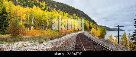 Voies de train le long du lac supérieur avec arbre dans le feuillage de couleur automnale; Ontario, Canada Banque D'Images