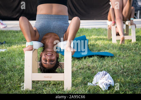 Girl in a yoga posture sur tabouret dans une classe de yoga au Wanderlust festival, à Lisbonne, Portugal. Banque D'Images