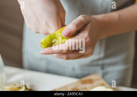 Découper les poires en salade sur une planche en bois faits maison - Recette - Mains de la ménagère - Rural Banque D'Images