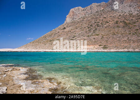 Stavros, la Canée, Crète, Grèce. Vue sur les eaux turquoise de la baie de Trahili jusqu'aux pentes accidentées de Vardies. Banque D'Images