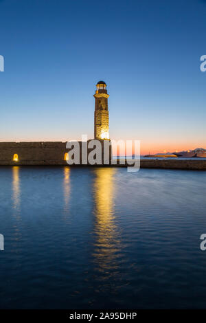 Rethymno, Crète, Grèce. Phare turc du XVIe siècle éclairé à l'entrée du port vénitien, à l'aube. Banque D'Images