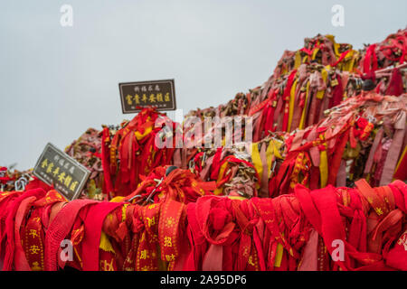 Huashan, Chine - Août 2019 : Mémorial symbolique religieuse et rubans rouges et cadenas verrouillé lié à des obstacles le long du chemin de Huashan Banque D'Images