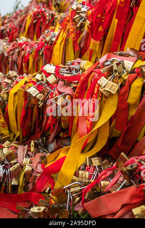 Huashan, Chine - Août 2019 : Mémorial symbolique religieuse et rubans rouges et cadenas verrouillé lié à des obstacles le long du chemin de Huashan Banque D'Images