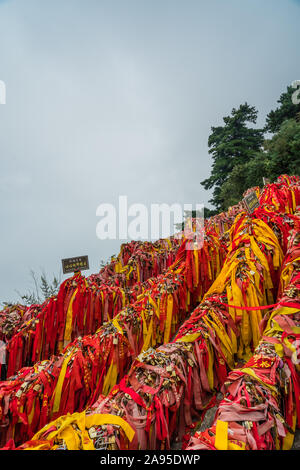 Huashan, Chine - Août 2019 : Mémorial symbolique religieuse et rubans rouges et cadenas verrouillé lié à des obstacles le long du chemin de Huashan Banque D'Images