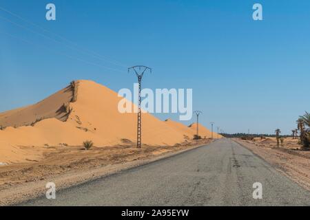 Route menant à travers l'sanddunes du Sahara, près de Timimoun, dans l'ouest de l'Algérie, l'Algérie Banque D'Images