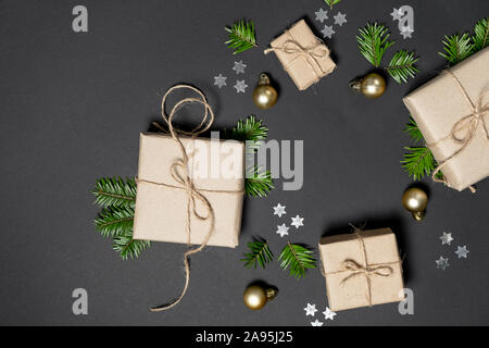 Composition d'hiver ou de noël. Cadeaux faits à la main avec du papier craft décorée de branches de sapins et les confettis sur fond sombre. Télévision lay, top vi Banque D'Images