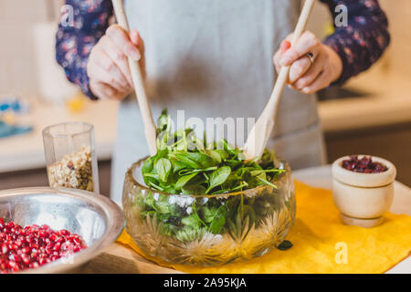 Une simple Recette - Salade d'Épinards, roquette, noix, poires, canneberges et Grenade - un plat de fête Banque D'Images