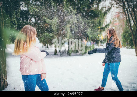 Sur une bonne journée d'hiver, deux amis jouer les boules dans une clairière dans le parc entre les arbres Banque D'Images