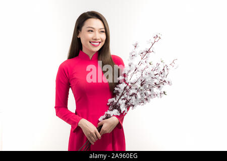 Beautiful Asian woman wearing Vietnam Ao dai traditionnel holding peach fleur en vacances du Têt. Banque D'Images