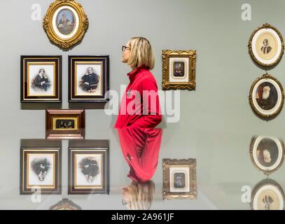 Edinburgh, Royaume-Uni. Novembre 13, 2019 Photo : l'une des galeries nationales d'Écosse examaning personnel certaines des photographies de l'exposition. Scotland's photograph Album : La Collection MacKinnon célèbre la vie et l'identité écossaise à partir de 1840 jusqu'aux années 1940. La collection, qui a été acquis par les amateurs de photographie Murray MacKinnon, a commencé lorsqu'il a couru une chaîne de magasins de traitement de film dans les années 1980, à partir de sa pharmacie à Dyce, près de Aberdeen.. Credit : Riche de Dyson/Alamy Live News Banque D'Images