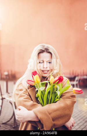 Début du printemps, mars - portrait d'une jeune blonde avec un joli bouquet de tulipes Banque D'Images