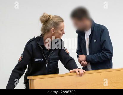 Hanovre, Allemagne. 13 Nov, 2019. Le défendeur accusé du meurtre de sa petite amie est conduit dans la salle d'audience. Il est censé avoir tué sa petite amie de Grohnde. Selon la cour, le défendeur souhaite s'engager. Le 25-year-old victime a saigné à mort sur les lieux en mai. Crédit : Peter Steffen/DPA - ATTENTION : personne(s) a été/sont pixelisées pour des raisons juridiques/dpa/Alamy Live News Banque D'Images