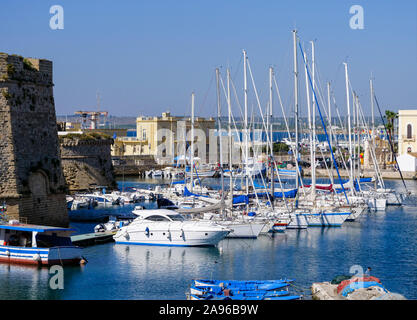 Voiliers dans le port méditerranéen à la destination de voyage dans les Pouilles Gallipoli sur un fond bleu ocean Banque D'Images