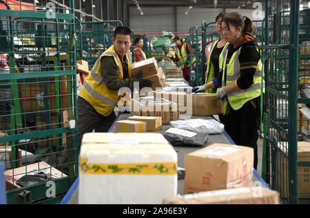 Les travailleurs chinois trier les colis du magasinage en ligne au cours de l'assemblée annuelle 11 Double shopping festival au centre de distribution et de tri d'un lo Banque D'Images