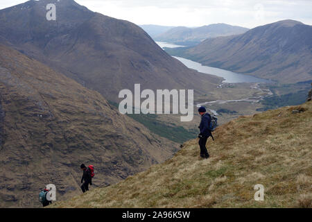 Trois hommes marchant dans l'herbe sur les montagnes écossaises Corbett Stob Dubh (Beinn Ceitein) dans la région de Glen Etive, Highlands, Ecosse, Royaume-Uni. Banque D'Images