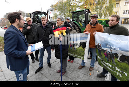 13 novembre 2019, le Schleswig-Holstein, Kiel : Jan Philipp Albrecht (l, Bündnis90/Die Grünen), le Schleswig-Holstein Ministre chargé de l'énergie, d'Agriculture, de l'environnement, de la nature et de la numérisation, parle de producteurs laitiers qui protestaient devant l'Landeshaus. Les producteurs laitiers organisés dans l'Association fédérale allemande des producteurs laitiers (BDM) remettent leurs offres d'Albrecht dans la perspective de la réunion des ministres de l'agriculture et de l'environnement. Photo : Carsten Rehder/dpa Banque D'Images