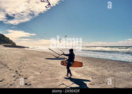 Un kite surfer promenades le long d'une plage dans le sud de la Californie, San Diego Banque D'Images