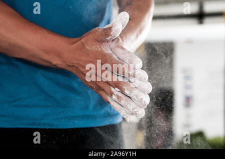 Gros plan du frottement sportsman magnésium poudre de craie blanche avec ses mains. Randonnées, l'entraînement fonctionnel et de la concurrence. Banque D'Images