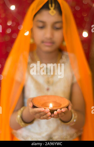 Girl holding diwali diya / lumière Banque D'Images