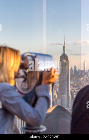 New York, USA - 17 mai 2019 : Rear View of Woman Peering Through Viseur Binoculaire à New York du Haut de la roche Banque D'Images