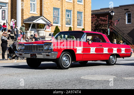 LINCOLNTON, NC, USA-11 nov 2019 : Chevrolet Impala 1964 Rouge conduit en défilé d'anciens combattants, avec panneaux imprimés en disant : "Army", "Air Force", "Coast Guard" Banque D'Images