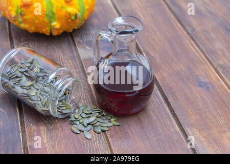 Les matières organiques naturelles de l'huile de graine de citrouille dans un bocal en verre sur la table en bois. Image avec copie espace Banque D'Images