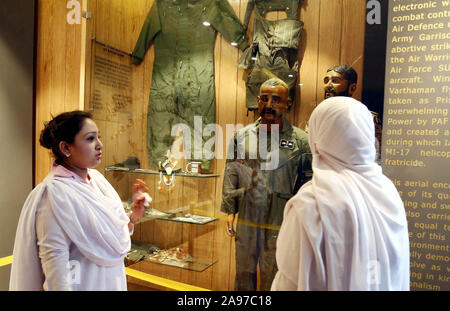 Les visiteurs prendre un vif intérêt dans la statue du pilote indien, commandant de l'Escadre Abhinandan Varthaman dont l'avion a été abattu au-dessus de l'Azad Cachemire, au Pakistan Air Force (PAF) Musée à Karachi le mercredi, Novembre 13, 2019. Le Pakistan a fait preuve d'une statue d'un pilote de l'armée de l'air indienne, qui a été pris comme prisonnier de guerre après son avion a été touché et arraché en escarmouches aériennes au début de cette année. Banque D'Images