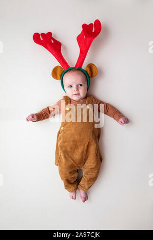 Un mignon petit bébé de deux mois de noël portant des bois de renne Banque D'Images