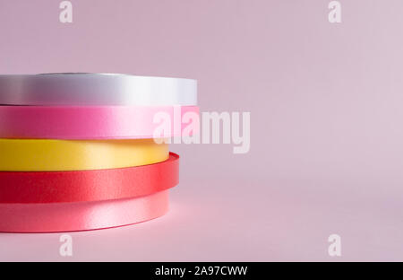 Pile de rouleau de ruban coloré sur fond rose Banque D'Images