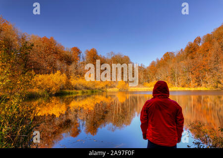 L'Azerbaïdjan, Shabran - Novembre 8, 2019 : randonneur surplombant un petit lac de montagne tandis que dans la forêt d'automne Banque D'Images