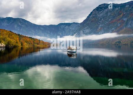 Une excursion en bateau sur un lac calme avec Bohinj couleur des feuilles d'automne, la Slovénie, l'Europe. Banque D'Images