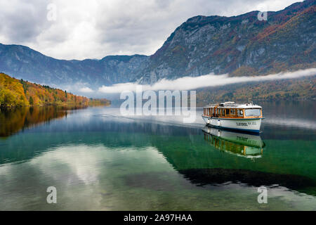 Une excursion en bateau sur un lac calme avec Bohinj couleur des feuilles d'automne, la Slovénie, l'Europe. Banque D'Images