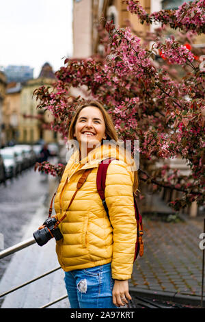 Jeune femme'prend des photos sur un voyage. Une femme avec un appareil photo dans ses mains promenades autour de la ville. Banque D'Images