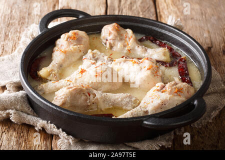 Bengali traditionnel blanc de poulet en sauce curry rezala avec piments du close-up dans une casserole sur la table. Banque D'Images