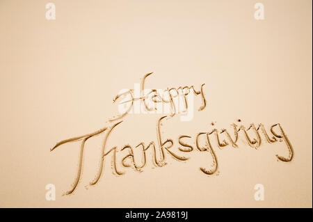 Message joyeux Thanksgiving écrits en calligraphie simple script sur plage de sable lisse Banque D'Images