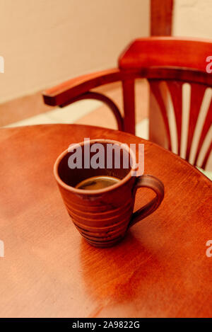 Tasse de café sur la table en bois Vintage. Tasse de café dans une tasse marron sur une table en bois. Table et chaise. Une tasse de café aromatique naturel préparé en t Banque D'Images