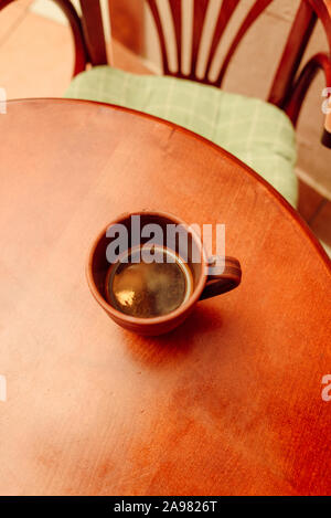 Tasse de café sur la table en bois Vintage. Tasse de café dans une tasse marron sur une table en bois. Table et chaise. Une tasse de café aromatique naturel préparé en t Banque D'Images