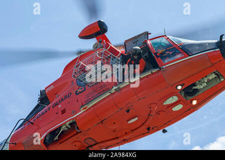 Le sentier descend un mécanicien de vol ligne à partir d'un hélicoptère Dauphin USCG MH-65. Banque D'Images