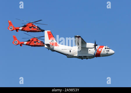 Une paire de MH-65 de la Garde côtière canadienne d'hélicoptères Dauphin Air Station San Francisco voler en formation serrée avec un C-27J Spartan d'Air Station Sacramento Banque D'Images