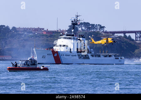 Une Garde côtière se distingue comme une sentinelle de la TDDSM United States Coast Guard MH-60 Jayhawk suspendu au-dessus du garde-côte de Constance (WMEC-623) avec des forces rep Banque D'Images