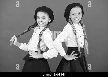 Sur la même vague. Usure uniforme de l'école formelle écolières. Les enfants belles filles de long cheveux tressés. Peu de filles avec des tresses, des prêts pour l'école. Concept de la mode de l'école. Style de fantaisie. L'École de l'amitié. Banque D'Images