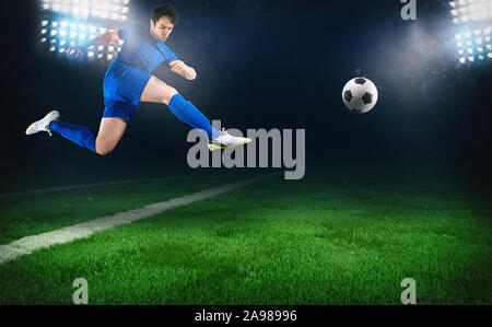 Scène de nuit football match avec un joueur de soccer en marche pour lancer la balle dans le stade Banque D'Images