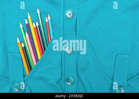 Crayons de couleur dans un pull bleu télévision de poche jeter l'arrière-plan. Banque D'Images