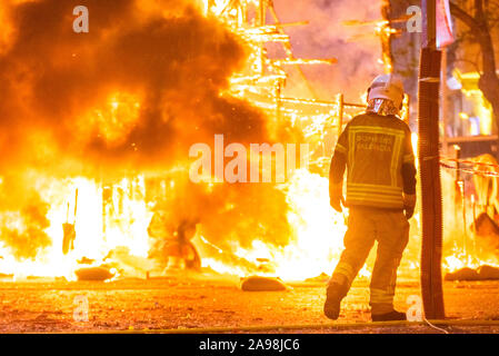 Pompiers autour d'un feu causé par une falla Valenciana contrôlant les flammes de l'incendie. Banque D'Images