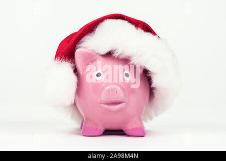 Little Christmas piggy bag avec chapeau de fête et fond blanc. Banque D'Images