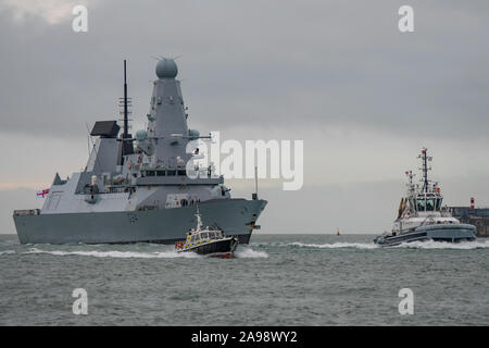 La Marine royale de la défense antiaérienne de la classe audacieuse destroyer HMS Diamond (D34) qui sont accompagnés par un remorqueur et le bateau de police vers Portsmouth, Royaume-Uni le 6/12/18. Banque D'Images