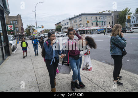 Une fille s'amusant dans la rue selfies après l'école à Brooklyn, New York Banque D'Images